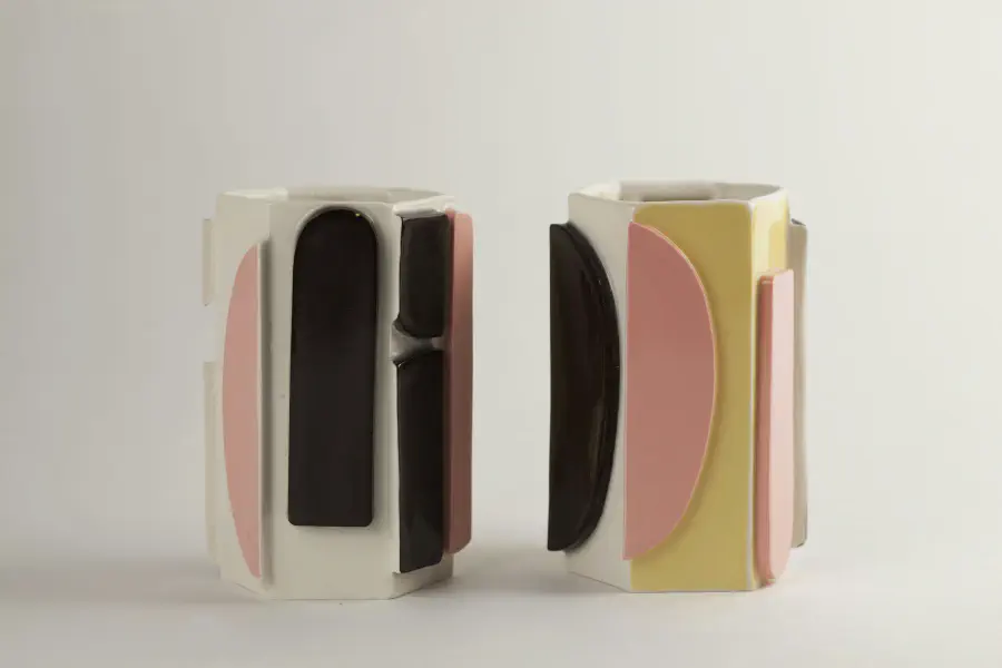 Three vases with panels added to the sides with yellow, pink, and black.