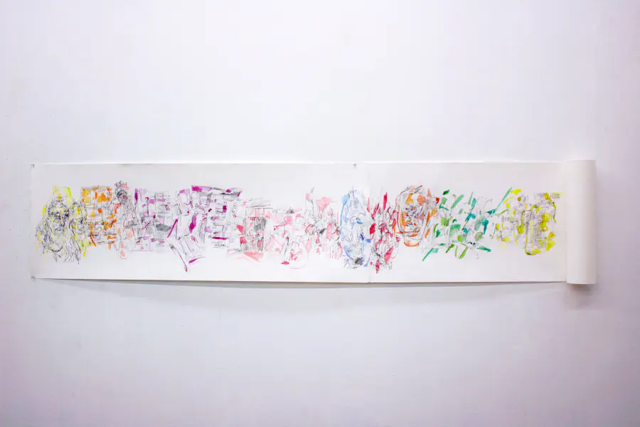 White wall with a curled, long sheet of paper pinned to it. The paper has a variety of watercolor splatters on it with graphite etchings.