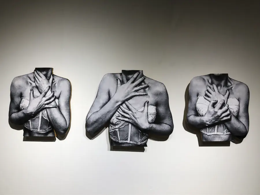 Three disembodied women's busts with hands clutching at her throat, chest, and wrists anxiously.