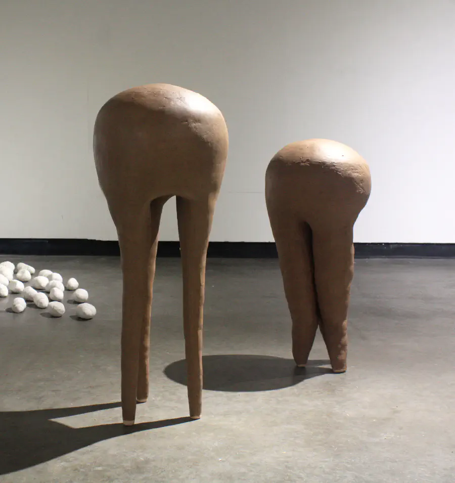 Two tooth-shaped structures standing near each other. The 'roots' look like legs, and the sculptures can be understood as deer.