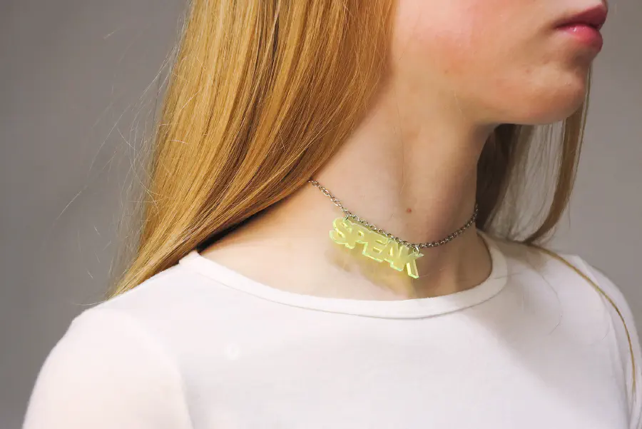 One of the figures wearing a necklace that says 'SPEAK.